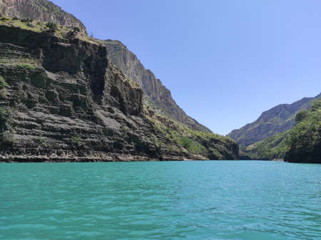 deep canyon with a blue river and beautiful mountains against the skyの写真素材