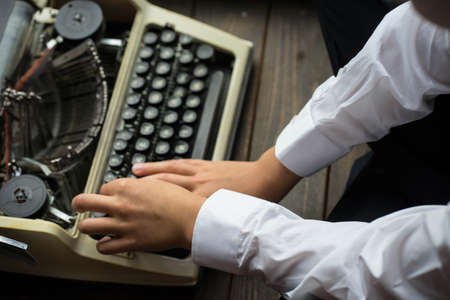boy typing on a printing machineの写真素材