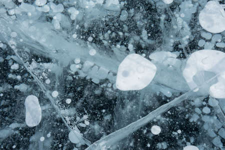 methane bubbles in a clear frozen lake in winter