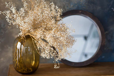 transparent vase of flowers stands on the tableの写真素材