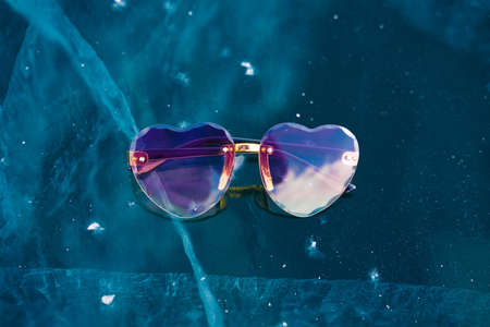 sunglasses lie on the transparent ice of the lake in winterの写真素材