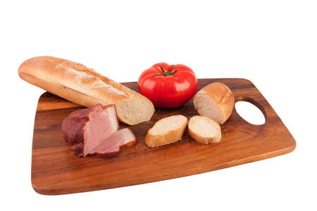 Baguette, tomato and ham on cutting boardの写真素材