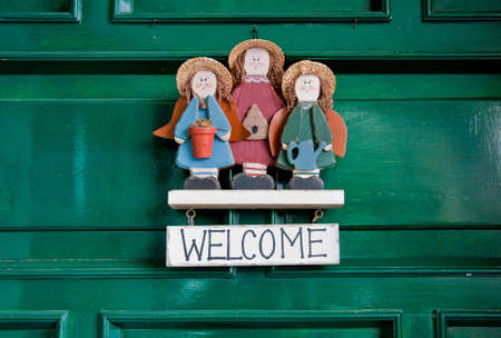 Welcome sign hanging at green doors.の写真素材
