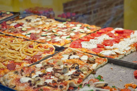 Four types of pizza in pan in pizzeria.の写真素材
