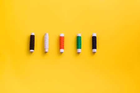 Reels with threads of different colors and sizes on a bright, colorful background. Flat layの写真素材