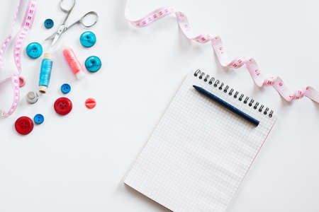Tools for cutting and sewing. Seamstress kit. Multi-colored reels of threads, tape, needles on a white backgroundの写真素材