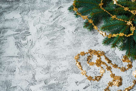 New Years or Christmas composition of spruce green branches and New Years, shiny golden toys and stars on a bright textural background. Flat lay, layout, frame, place for text, copy space, top viewの写真素材