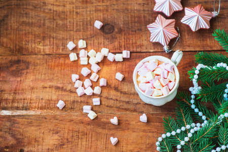Christmas background. Composition of spruce branches Christmas balls, cup with coffee with marshmallows on a wooden background. Copy space Top view. Christmas or New Years card. flat layの写真素材