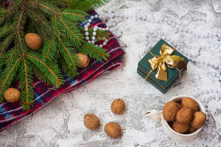 New Year's or Christmas composition of spruce green branches, red plaid, walnuts, gift and Christmas lollipops on a bright textural background. Flat lay, layout, frame, copy spaceの写真素材