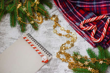 New Year's or Christmas composition of spruce green branches, warm plaid, New Year's garland,...