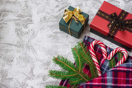 New Years or Christmas composition of spruce green branches, warm plaid, New Years gift and...