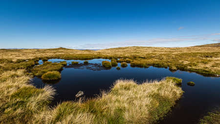 Blue sky reflecting in a mountain lake in Cairngorms National Park, Scotland.の写真素材