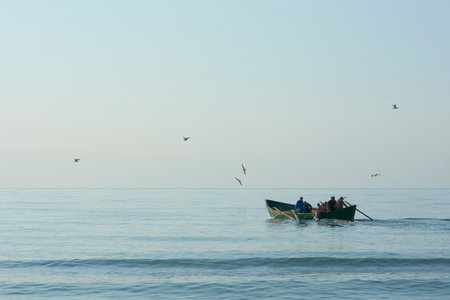 fishing boat with fishermen at seaの写真素材