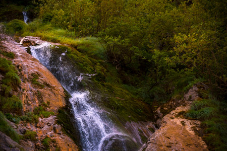 waterfall with flowing water in the mountainの写真素材
