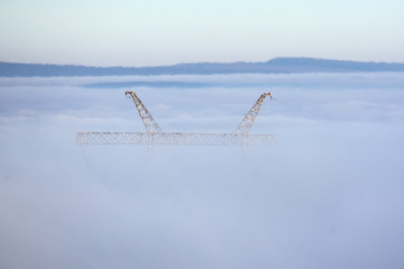 high voltage cables and poles in the fogの写真素材