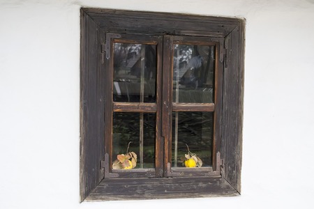A old window with two  quinces in front on a white wall background の写真素材