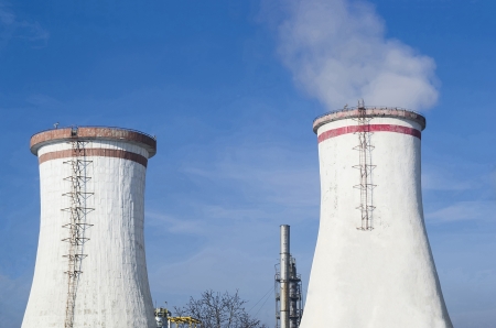Two white cooling towers and petrochemical installations in the backgroundの写真素材