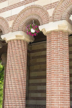 Two byzantine style columns with a pansy flowerpot under their arcadeの写真素材