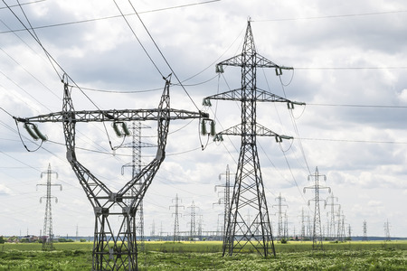 Two types of electrical power lines towers withing a large network for energy distributionの写真素材