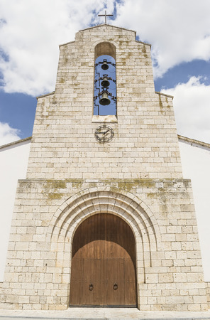 Old catholic church entrance with three overlapped bells and iron clock attached to the wallの写真素材