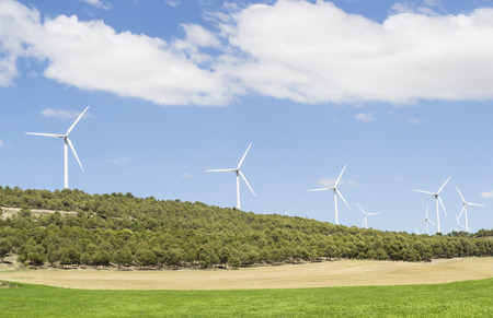Several wind turbines installed on a hill for harvesting wind energyの写真素材