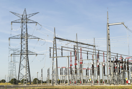 Rows of high voltage power lines carrying electricity from a nearby electrical stationの写真素材