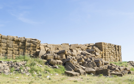 Huge stacks of straw bales gathered from the field which collapsed under their own weightの写真素材