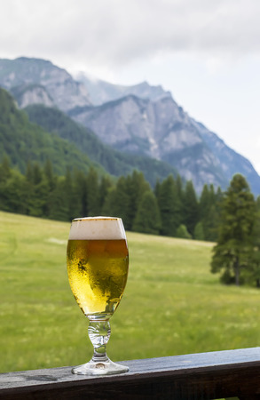 Glass of  cold beer served in a mountain areaの写真素材