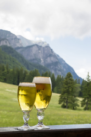Two glasses of cold beer , served in a mountain landscapeの写真素材