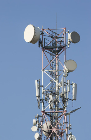 Telecommunications tower with parabolic antennas and mobile phone electronic equipmentの写真素材