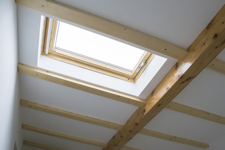Skylight installed on the roof of a house attic for illumination and ventilation, interior viewのeditorial素材