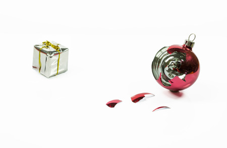 Christmas glass ball broken with small gift box, in white backgroundの写真素材