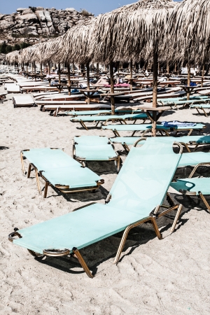 Loungers under palm tree leaves umbrellas on the beach ( HDR image )の写真素材