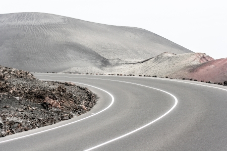 Empty road crossing an arid mountain, Lanzarote, Canary islands, Spain の写真素材