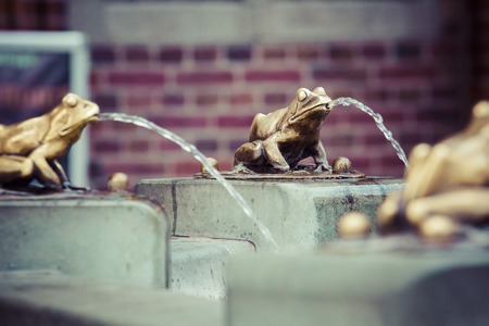 Fountain with golden lucky frog - the symbol of Torun city (Poland)の写真素材