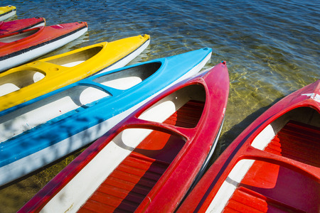 Colorful kayaks moored on lakeshore, Goldopiwo Lake, Mazury, Poland.の写真素材