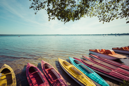 Colorful kayaks moored on lakeshore, Goldopiwo Lake, Mazury, Poland.の写真素材