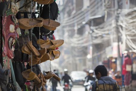 Traditional nepali hempen shoes and vest leaning against a red wall in a shop in Durbar Square-Kathmandu-Nepal.のeditorial素材
