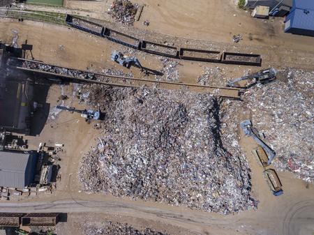 Iron raw materials recycling pile, work machines. Metal waste junkyard. View from above.の写真素材