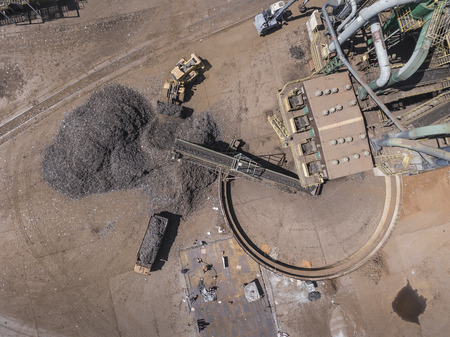 Iron raw materials recycling pile, work machines. Metal waste junkyard. View from above.