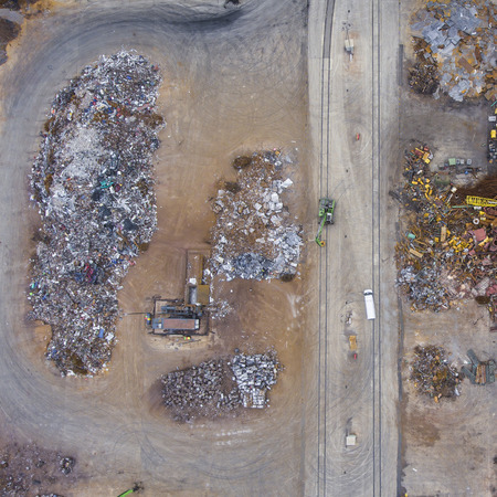 Iron raw materials recycling pile, work machines. Metal waste junkyard. View from above.の写真素材