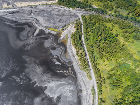 Degraded landscape in south of Poland. Destroyed land. View from above. Black lake.