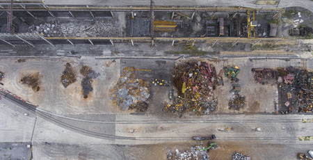 Iron raw materials recycling pile, work machines. Metal waste junkyard. View from above.の写真素材