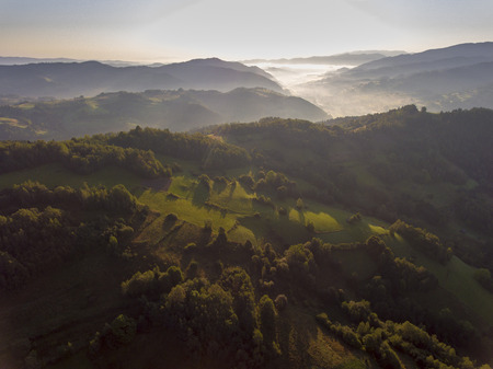 Landscape misty panorama. Fantastic dreamy sunrise on rocky mountains with view into misty valley below. Foggy forest hills. View from above. Ochotnica Dolna village, Poland.の写真素材