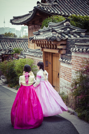 SEOUL - SOUTH KOREA - OCTOBER 21, 2016 : A couple women wander through the traditional style houses of Bukchon Hanok Village in Seoul, South Korea.のeditorial素材