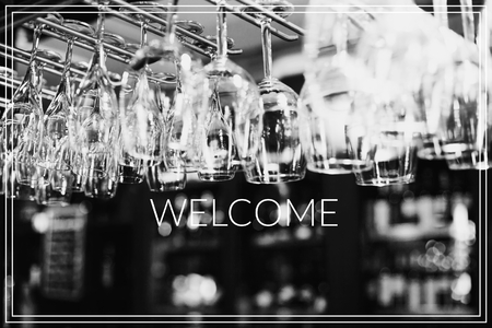Welcome. Empty glasses for wine above a bar rackの写真素材