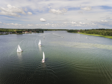 Aerial view of green islands and clouds at summer sunny morning. Masurian Lake District  in Poland. Wonders of the world from above. Yachts sailing in the lake.の写真素材