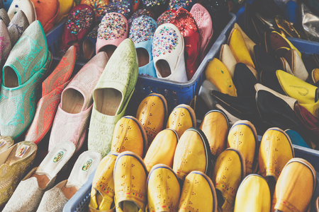 Colorful Moroccan shoes alignment in a shop. Oriental shoes in a bazaar. Multicolored Moroccan slippers. Colorful leather slippers for sale in the souk in Marrakech.の写真素材