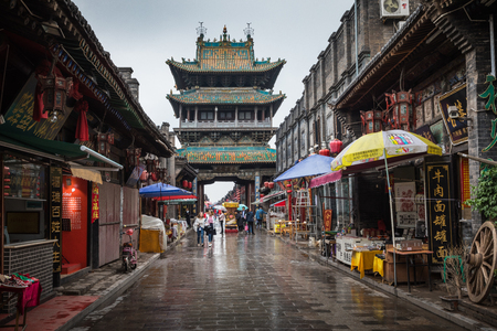 PINGYAO, CHINA - MAY 21, 2018: Tourists and local people in the ancient city of Pingyao in central China, Asia. Rainy weather.のeditorial素材