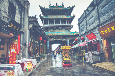 PINGYAO, CHINA - MAY 21, 2018: Tourists and local people in the ancient city of Pingyao in central China, Asia. Rainy weather.のeditorial素材
